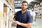 Warehouse worker using digital tablet in distribution warehouse