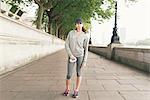 Full length portrait of female runner holding water bottle