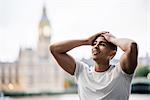 Exhausted male runner taking a break on Southbank, London, UK