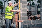 Workers laying bricks on construction site