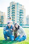 Portrait of mid adult couple with toddler daughter on shoulders in park