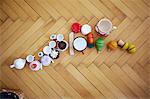 Overhead view of cupcakes, toys and cups on parquet floor