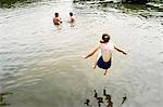 Rear view of girl jumping into lake