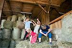 Group of children in stable playing with hay