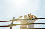 Low angle view of young couple holding wine glasses looking away