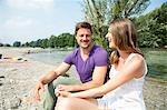 Young couple resting on the riverbank