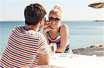 Young couple sitting at table in beach bar