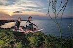 Surfers sitting on surfboard