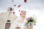 Bride with bouquet and falling rose petals