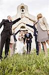 Newly wed couple leaves chapel surrounded by wedding guests