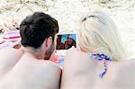 Young couple using digital tablet on beach