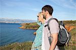 Young couple on coastal path looking at sea