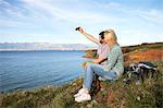 Young couple taking self portrait on cliff