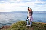 Young couple on cliff looking at sea
