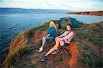 Two women at campsite looking at sea