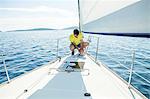 Man adjusting rigging on sailboat, Adriatic Sea