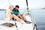 Couple using digital tablet on sailboat, Adriatic Sea