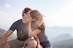 Young couple kissing on mountain peak