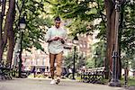 A man walking through a town square looking at his smart phone