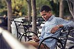 A man in a park looking at a smart phone