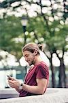 A young man in a park checking his cell phone