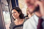 A woman on a busy bus looking out of the window