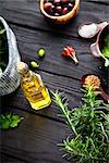 Olive oil with herbs. Mediterranean ingredients: rosemary, olives, thyme, sage, salt, oregano