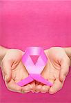 Woman holding a pink cancer awareness ribbon in her hands