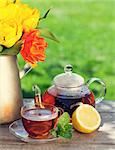 Breakfast tea on garden table and colorful tulips bouquet