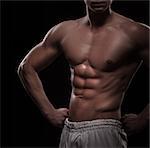 Beautiful athletic man torso isolated over black background