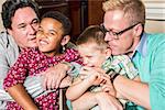 Gay parents kissing and hugging their children