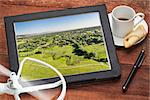 aerial photography concept - reviewing aerial pictures of Fort Collins downtown on a digital tablet with a drone rotor and coffee, screen picture copyright by the photographer