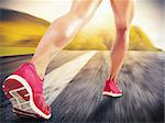 Legs of sporty woman running on asphalt