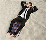 Businessman relaxes lying on a beach chair