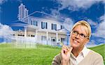 Smiling Woman Holding Pencil Looking Over to Ghosted House Drawing, Partial Photo and Rolling Green Hills Behind.