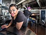 Dark haired smiling cashier with blue eyes on food truck