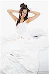 Stock image of woman in bed, white bedding