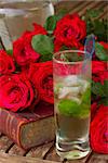vintage old book  on table with roses and long drink