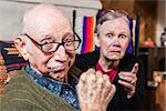 Tough elderly couple indoors with aggressive gesturing