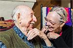 Happy Caucasian elderly couple sitting indoors smiling