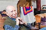 Smiling elderly man sitting on a chair indoors