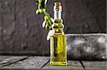 Extra virgin healthy Olive oil with fresh olives on dark wooden background