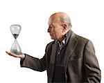 Elderly man holds an hourglass in hand