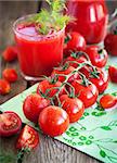 Fresh tomatoes and tomato juice on wooden table