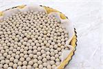 Close-up of pastry weights, ceramic beans, in an unbaked pie case lined with baking parchment