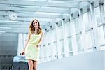 Smiling girl with a suitcase at the airport