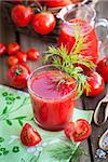 Tomato juice and fresh tomatoes on wooden table
