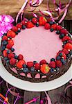 Raspberry cheesecake decorated with fresh berries and chocolate