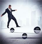 Businessman balancing on boards with iron balls