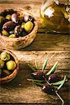olives on olive branch. Wooden table with olives and olive oil